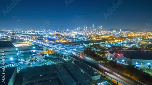 Aerial evening timelapse in motion (hyperlapse) facing downtown Los Angeles after sunset with stunning deep blue sky buildings, and car lights with traffic on a busy street below. photo