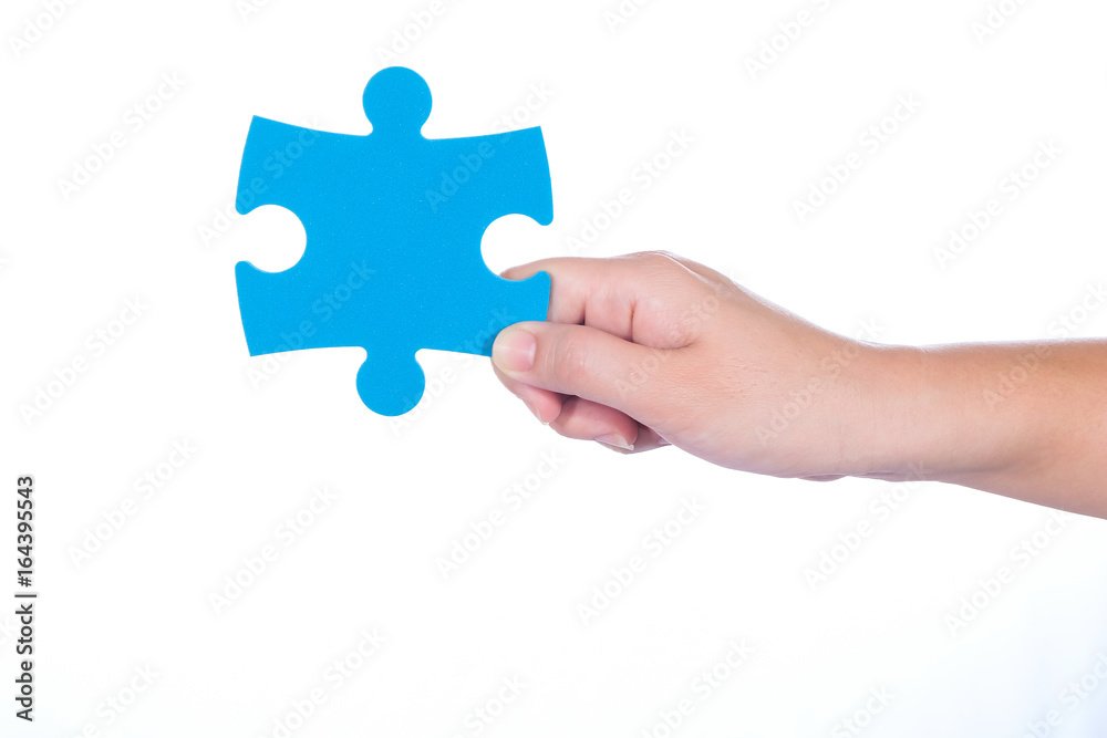 Hand holding jigsaw isolated on white background Hand holding jigsaw isolated on white background