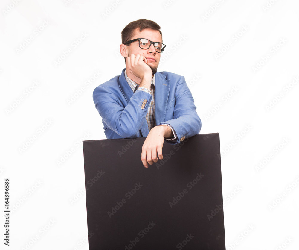 Young thoughtful man portrait of a confident businessman showing presentation, pointing placard gray background. Ideal for banners, registration forms, presentation, landings, presenting concept. Young thoughtful man portrait of a confident businessman showing presentation, pointing placard gray background. Ideal for banners, registration forms, presentation, landings, presenting concept.