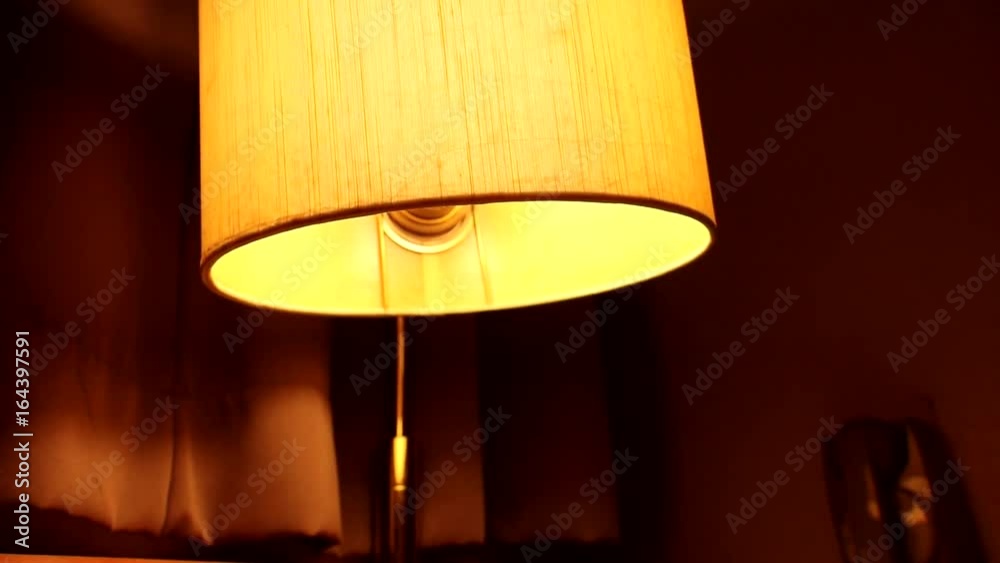 Nostalgic room in the old hotel. The old lamp shining at retro radio. Vintage bedroom with radio and a table lamp above the bed.