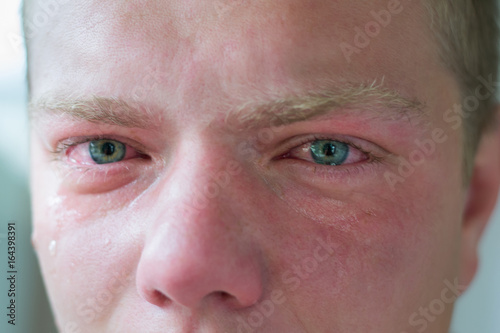 Face of crying adult man with blue eyes