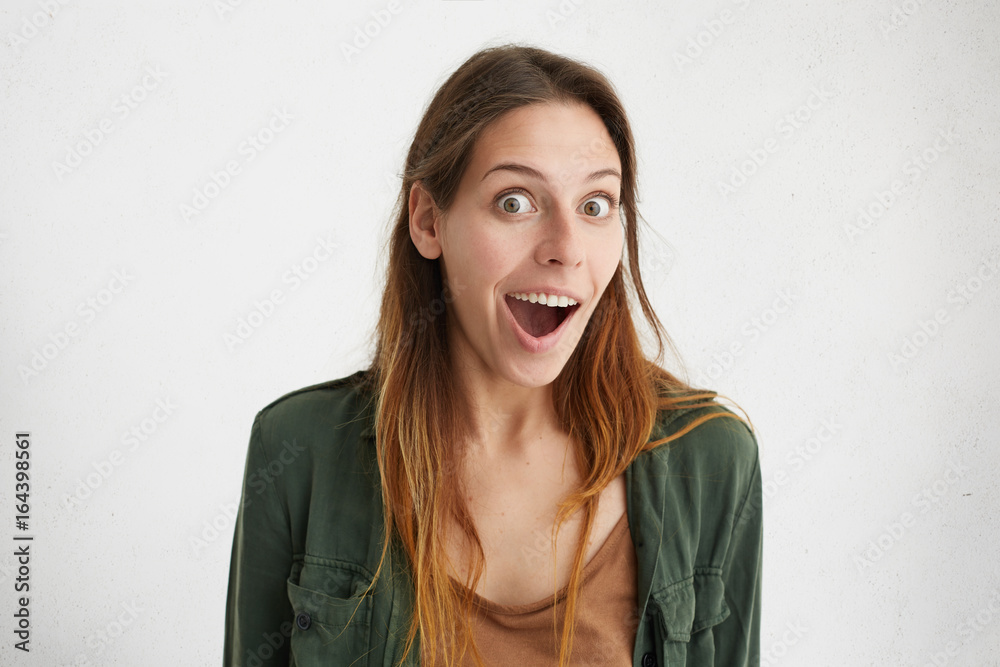 Embarrassed young beautiful woman with dyed hair looking with opened mouth and surprised eyes isolated over white background. Amazed pretty female demonstrating her surprisment and disbelief Embarrassed young beautiful woman with dyed hair looking with opened mouth and surprised eyes isolated over white background. Amazed pretty female demonstrating her surprisment and disbelief