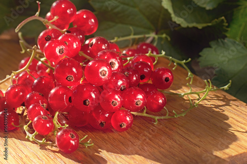 Heap of red currant on wooden background