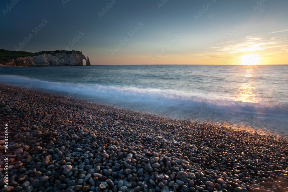 Sunset at the pebbled beach, Porte d'Aval and L'Aiguille at Etretat, a commune in the Seine-Maritime department in the Normandy region of north western France