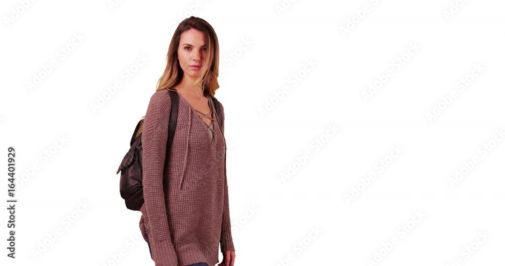 Portrait of Caucasian girl in her 20s wearing backpack, smiling at camera on white background with copyspace. Portrait of young white woman with backpack standing in studio with copy space. 4k Portrait of Caucasian girl in her 20s wearing backpack, smiling at camera on white background with copyspace. Portrait of young white woman with backpack standing in studio with copy space. 4k