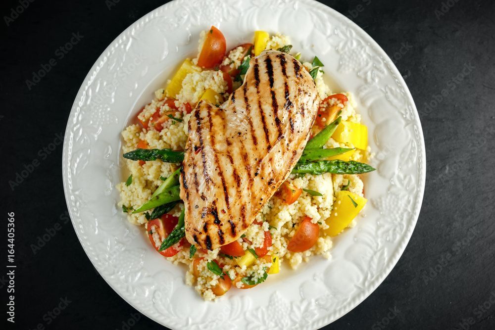 couscous salad with grilled chicken and asparagus on white plate. stone table. healthy food couscous salad with grilled chicken and asparagus on white plate. stone table. healthy food