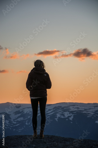 Young woman enyoing sunrise in the mountains