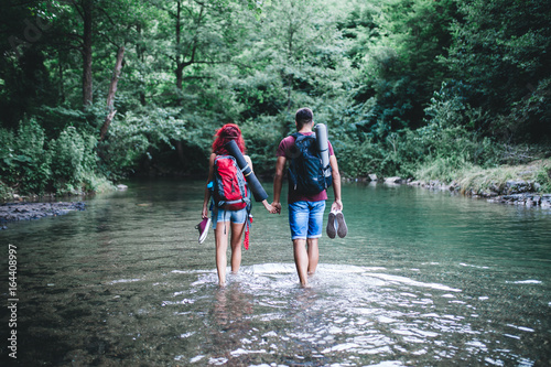 Fototapeta Naklejka Na Ścianę i Meble -  Young happy couple enjoying together in wild mountain river.