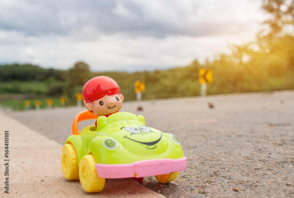 Obraz premium miniature car toy model with driver at Curve sign road, transport concept