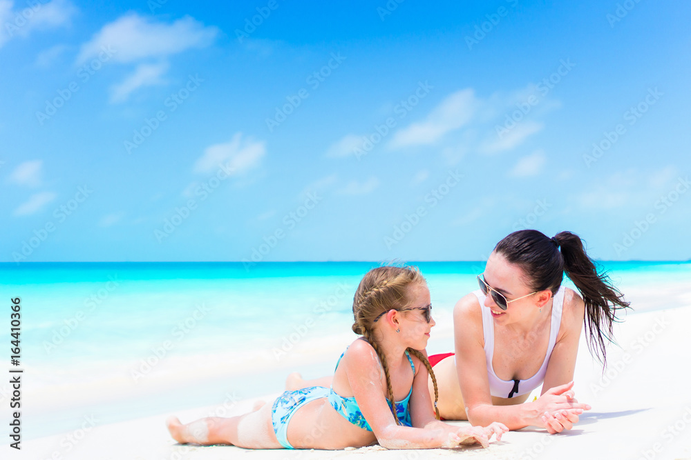 Little cute girl and young mother at tropical beach Little cute girl and young mother at tropical beach