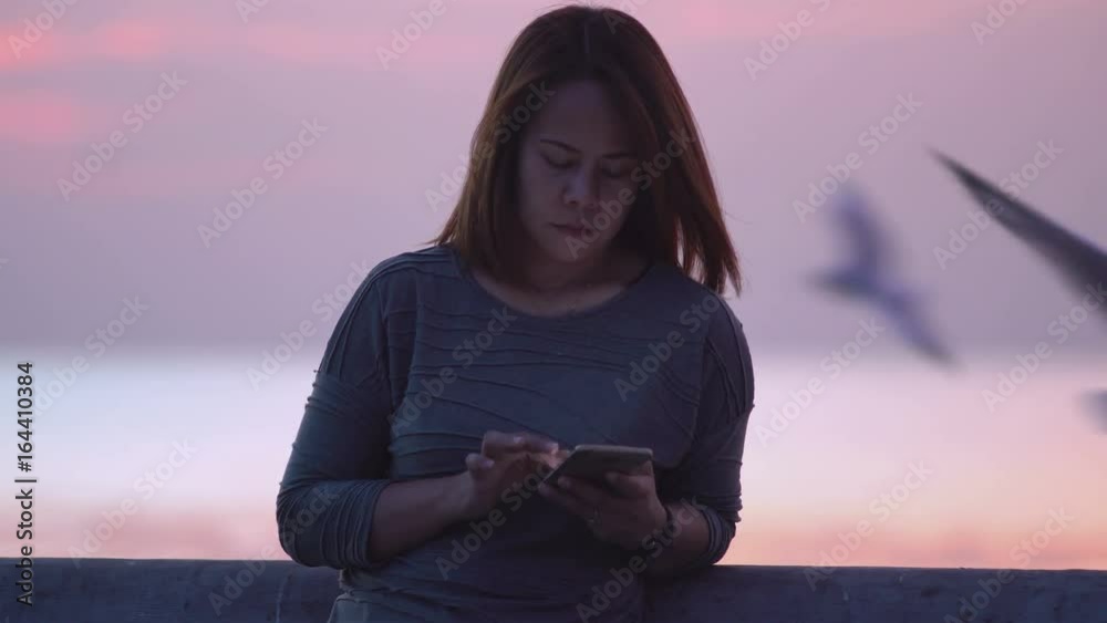 Woman use smartphone to chat my her friend and reading message very happy at sunset Bang Pu Samut Prakan, Thailand