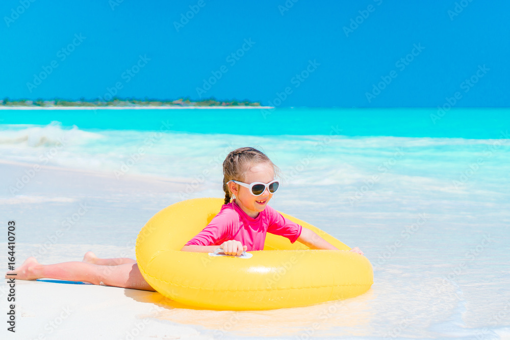 Adorable little girl with inflatable rubber circle splashing. Kid having fun on summer active vacation