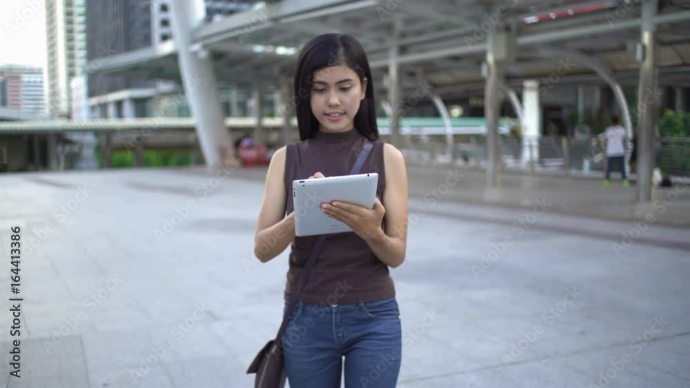 Woman using tablet very happy in downtown of Bangkok.Lifestyle concept. Woman using tablet very happy in downtown of Bangkok.Lifestyle concept.