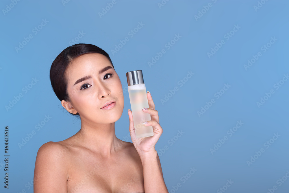 Young smiling female holding a white blank round jar bottle of Cosmetic skin care package product Young smiling female holding a white blank round jar bottle of Cosmetic skin care package product