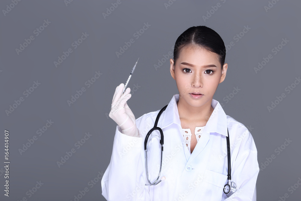 Beautiful Asian Tan Skin Woman Doctor White Shirt suit with stethoscope on neck and syringe needle in hand Beautiful Asian Tan Skin Woman Doctor White Shirt suit with stethoscope on neck and syringe needle in hand
