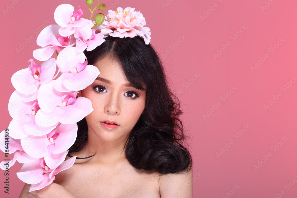 Beautiful Asian Woman black hair with flora crowd, holding bouquet artificial rose over chest