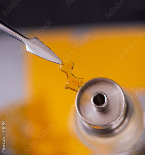 Dabbing tool with small piece of cannabis oil aka shatter - medical marijuana concentrates concept