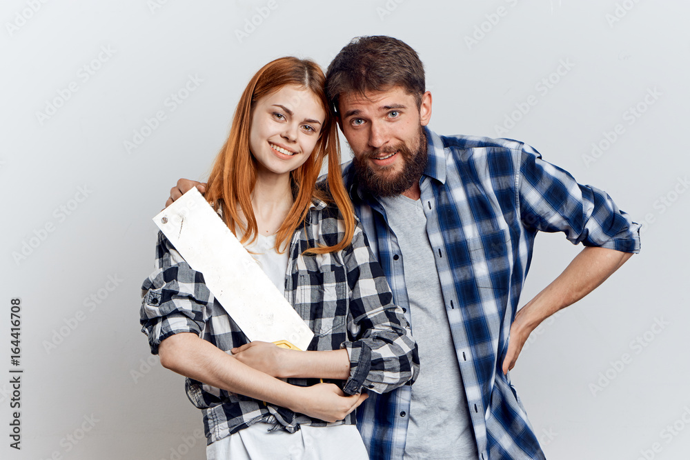 Naklejka premium Young beautiful woman and guy with beard on white isolated background, repair, building materials, tools
