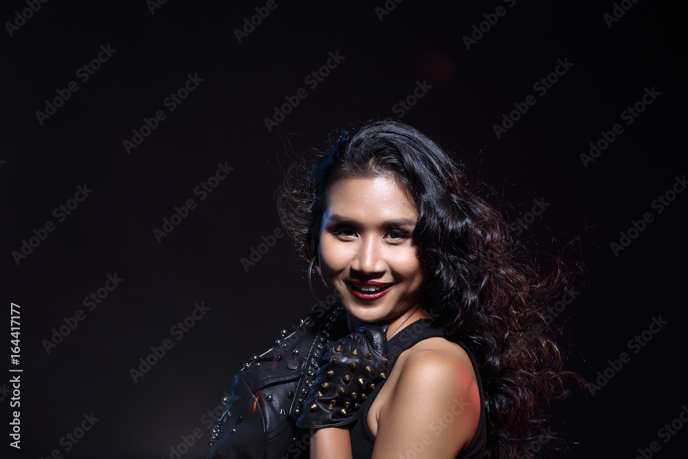 low key portrait of tan skin asian slim healthy woman in black background