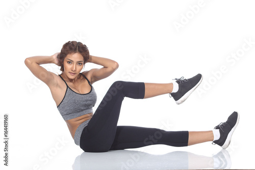 Tan Skin Asian Fitness Girl in Sexy Cute Sport Bra black spandex pants Exercise warm up in white studio room, practice pose sit up and raise one leg