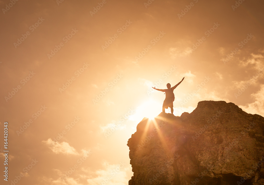 Man on top a mountain celebrating. Victory and success concept. 