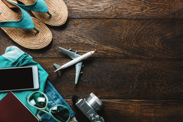 Top view accessories  travel with mobile phone,camera,sunglasses,cloth woman,sandal on table wooden with copy space.vacation and holidays beach concept.fashion women.flat lay.above.copy space.