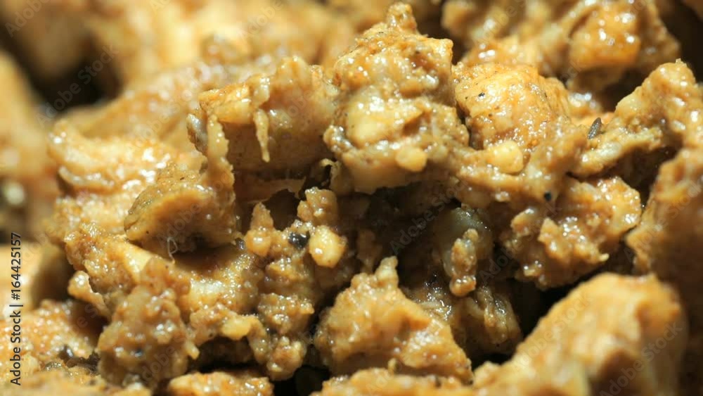 The spoon mixes fried slices during frying. The process of frying the chopped chicken pieces for cooking kebabs on the cast iron skillet. Close-up The spoon mixes fried slices during frying. The process of frying the chopped chicken pieces for cooking kebabs on the cast iron skillet. Close-up