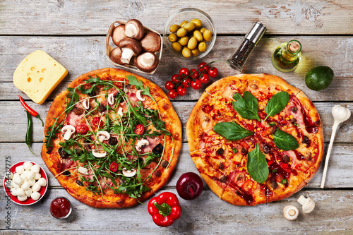 Appetizing sliced pizzas, wooden background.