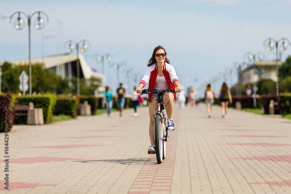 Urban biking - young woman riding bike 