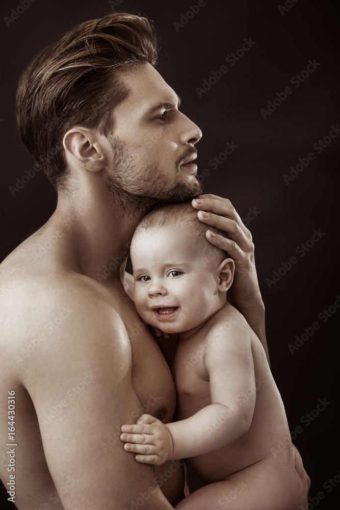 Handsome, muscular father carrying gis cute son Handsome, muscular father carrying gis cute son