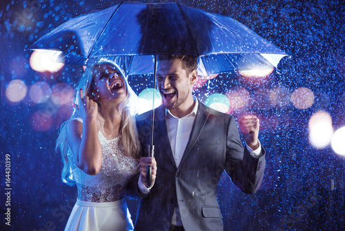 Fashion style portrait of a couple posing in the rainy weather