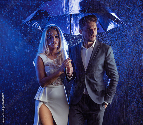 Fashion style portrait of a couple posing in the rainy weather