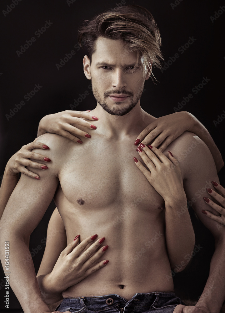 Fototapeta premium Handsome man being touched by many female hands