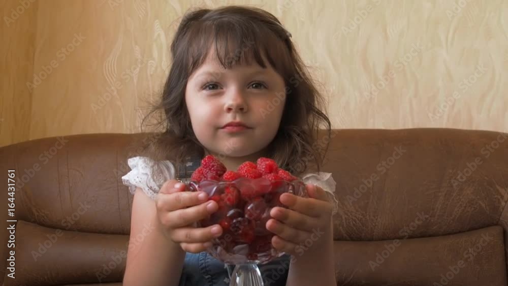 Child with raspberries. A little girl is holding raspberries in her hands. Child with raspberries. A little girl is holding raspberries in her hands.