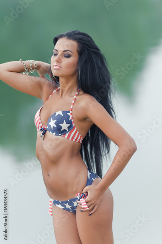 Young beautiful black-haired woman posing on the beach