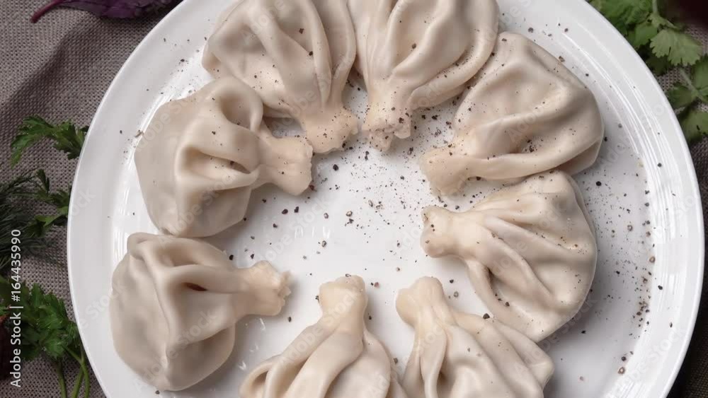 khinkali is spinning on a plate and sprinkle with pepper khinkali is spinning on a plate and sprinkle with pepper