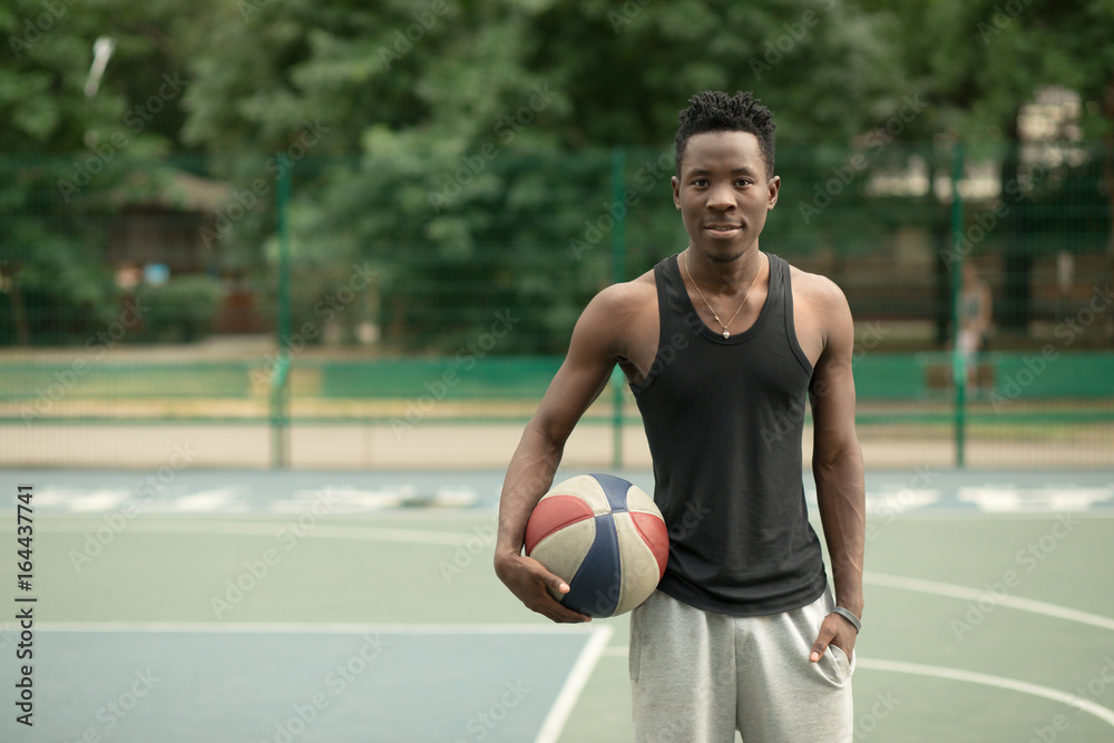 Portrait of african american man on basketball court keep ball