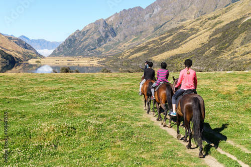 Horse riding in mountains by lake