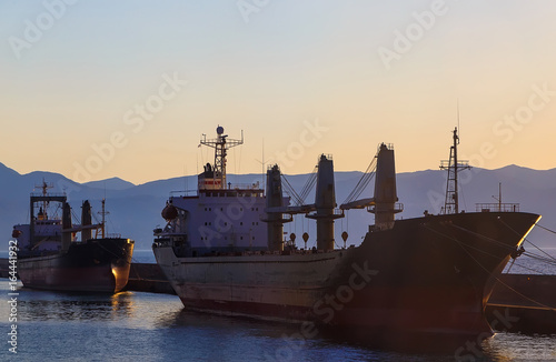 Two cargo ship in port of Heraklion City at sunset and the mountains. Greece.