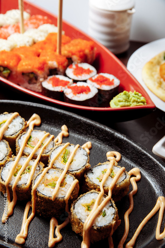 Sushi and rolls on a wooden table.