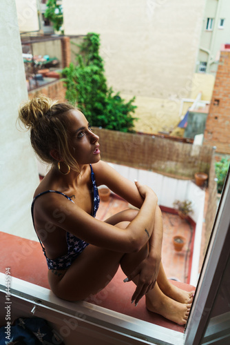 Sensual woman in swimming suit in window