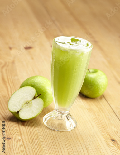 Glass of apple juice on wooden table