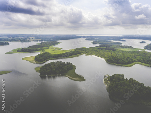 Aerial view of green islands and clouds at summer sunny morning. Masurian Lake District in Poland.