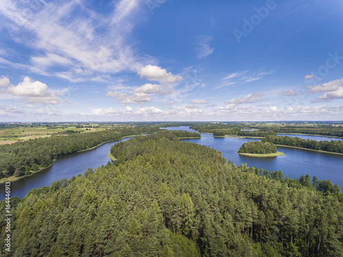Aerial view of green islands and clouds at summer sunny day.Wydminy lake on Masuria in Poland.