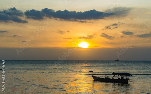 Silhouette of fishing boat on the beach in golden sunset