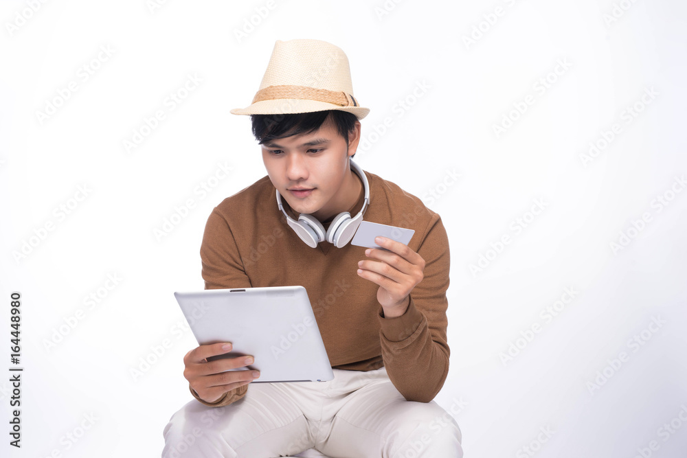 Smart casual asian man seated on chair, shopping online with credit card and smartphone Smart casual asian man seated on chair, shopping online with credit card and smartphone