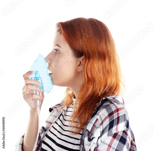 Young woman using nebulizer...