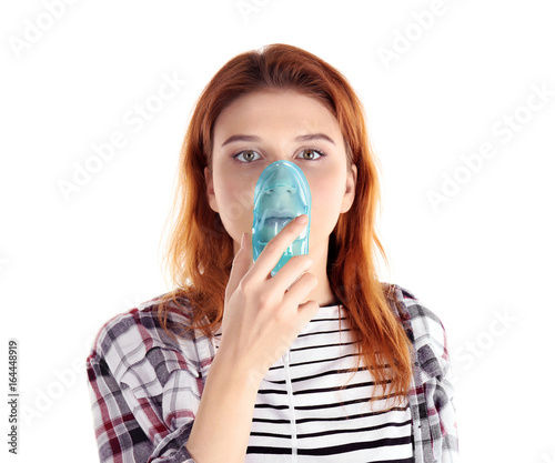 Young woman using nebulizer...