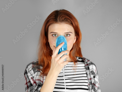 Young woman using nebulizer...