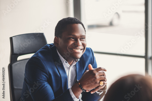 Portrait of a businessman in front of his team photo